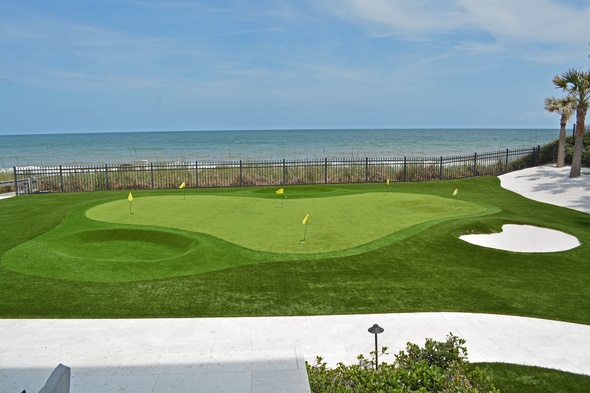 Naperville Synthetic grass golf green by the sea with yellow flags and a sand bunker