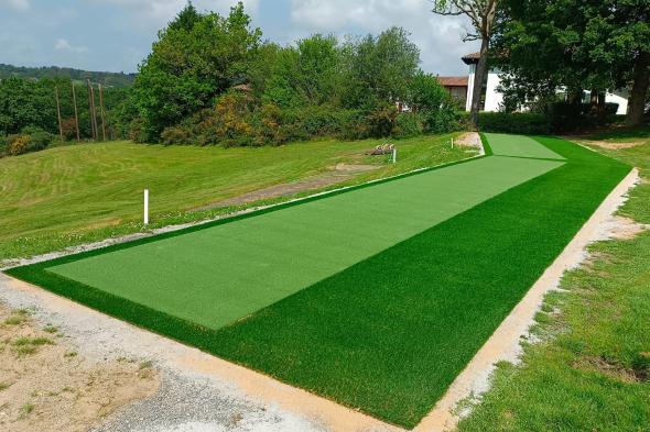Naperville Outdoor tee line consisting of one continuous green synthetic grass strip surrounded by trees