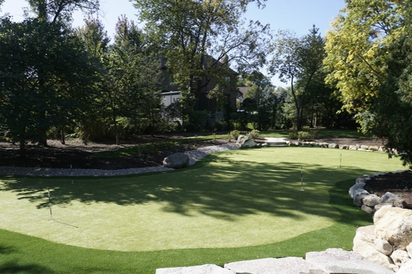 Naperville backyard putting green grass with flags and pink flowers